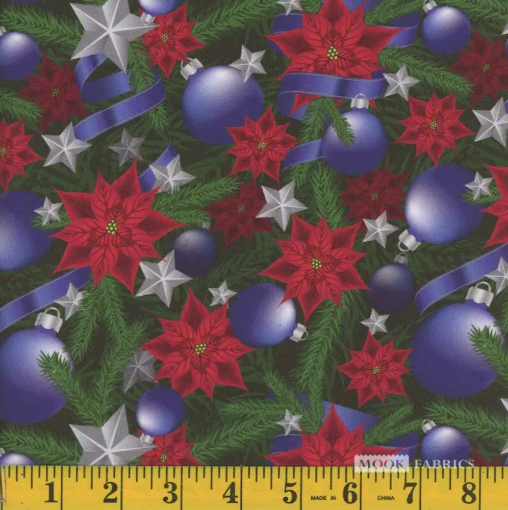 A yardstick measuring the width of fabric featuring Christmas-themed patterns including blue ornaments, ribbons, silver stars, and red poinsettias on a green leafy background.