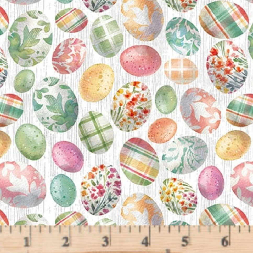 Pattern of colorful Easter eggs on a white background with a ruler for scale.